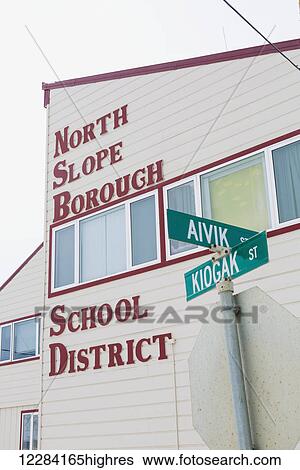 Stock Photograph - Exterior view of red lettering on the outside of the North Slope Borough School District Building, Barrow, North Slope, Arctic Alaska, USA, Winter. Fotosearch
