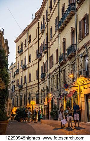 Families on the street outside shops at dusk; Cagliari, Sardinia, Italy View Large Photo Image Stock Photograph - Families on the street outside shops at dusk; Cagliari, Sardinia, Italy. Fotosearch