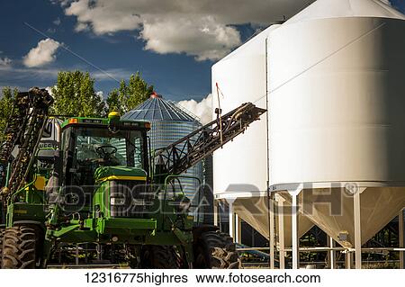 Farm equipment and grain storage bins on a farm; Saskatchewan, Canada View Large Photo Image Stock Photograph - Farm equipment and grain storage bins on a farm; Saskatchewan, Canada. Fotosearch