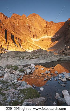 Stock Photograph - First light on Long's Peak at Chasm Lake in Rocky Mountain National Park; Colorado, United States of America. Fotosearch