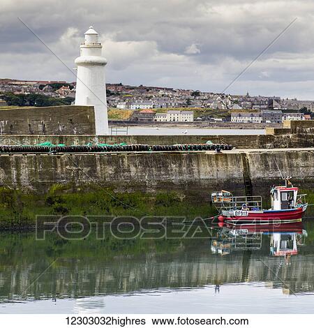 Fishing boat moored in a tranquil harbour with a white lighthouse and cityscape; Macduff, Aberdeenshire, Scotland View Large Photo Image Stock Photograph - Fishing boat moored in a tranquil harbour with a white lighthouse and cityscape; Macduff, Aberdeenshire, Scotland. Fotosearch