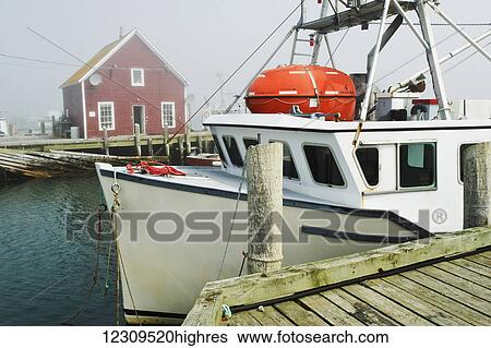Stock Photograph - Fishing boat tied to wharf; Cape Forchu, Nova Scotia, Canada. Fotosearch