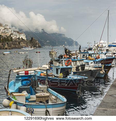 Stock Photograph - Fishing boats mooring in the harbour along the Amalfi coast; Amalfi, Campania, Italy. Fotosearch