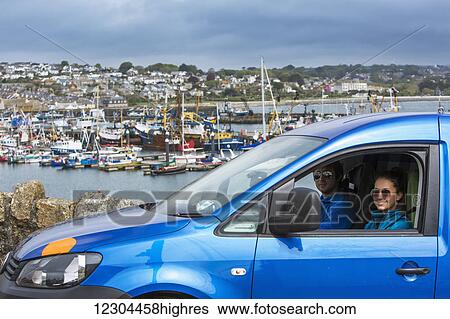 Stock Photograph - Friends explore Newlyn, a small fishing village on the South Western tip of Cornwall; Newlyn, Cornwall, England. Fotosearch