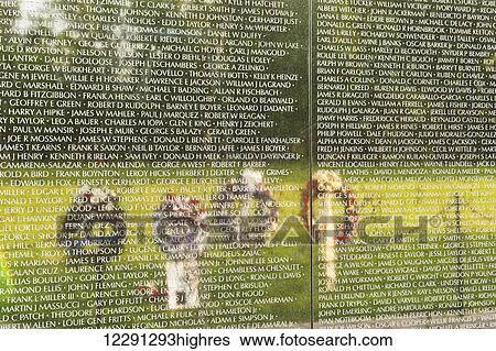Stock Photograph - Funeral wreaths reflect in the surface of the wall at the Vietnam Veterans Memorial; Washington, District of Columbia, United States of America. Fotosearch
