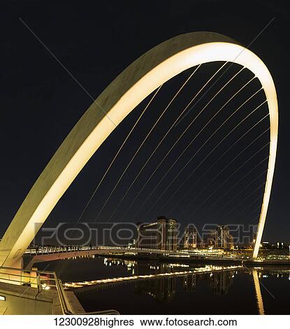 Stock Photograph - Gateshead Millennium Bridge at nighttime; Gateshead, Tyne and Wear, England. Fotosearch