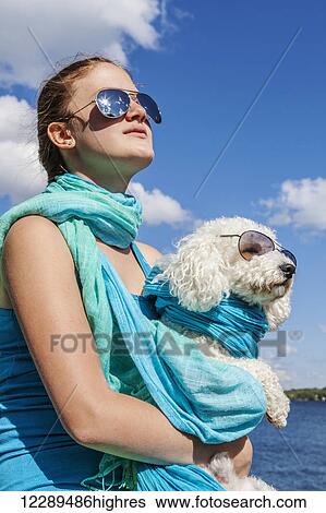 Stock Photograph - Girl and her dog wearing matching sunglasses; Balsam Lake, Ontario, Canada. Fotosearch