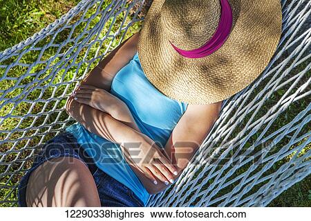 Girl resting in hammock under sun hat; Ontario, Canada View Large Photo Image Stock Photograph - Girl resting in hammock under sun hat; Ontario, Canada. Fotosearch