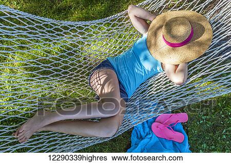 Girl resting in hammock under sun hat; Ontario, Canada View Large Photo Image Stock Photograph - Girl resting in hammock under sun hat; Ontario, Canada. Fotosearch