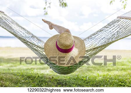 Stock Photograph - Girl resting on hammock by Balsam Lake; Ontario, Canada. Fotosearch