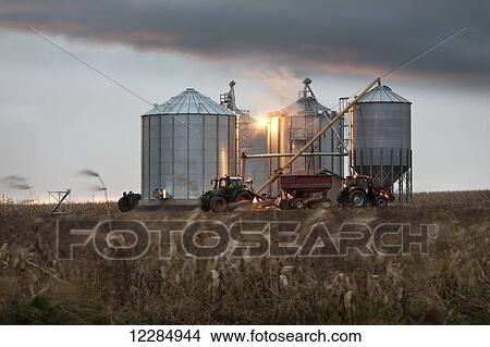 Grain silos and tractor under a dramatic sky at sunset; Quebec, Canada View Large Photo Image Picture - Grain silos and tractor under a dramatic sky at sunset; Quebec, Canada. Fotosearch