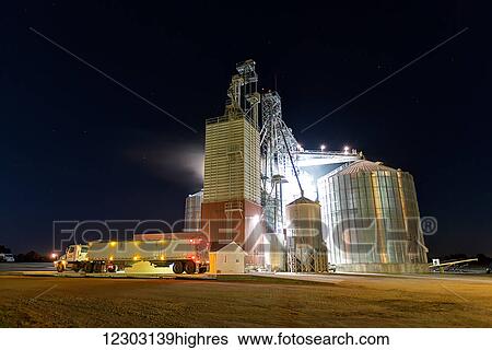Grain truck parked in front of the Edgewood Feed Mill grain elevator site at night; Edgewood, Iowa, United States of America View Large Photo Image Stock Photograph - Grain truck parked in front of the Edgewood Feed Mill grain elevator site at night; Edgewood, Iowa, United States of America. Fotosearch