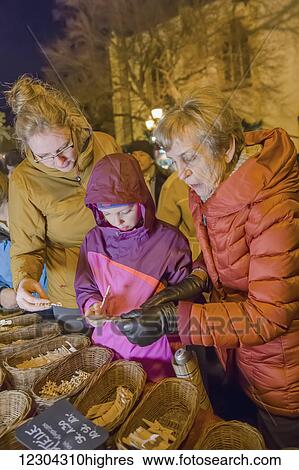 Stock Photograph - Grandmother, mother and daughter shopping at the Christmas market in the heart of the old town; Altenahr, Nordrhein Westfalen, Germany. Fotosearch