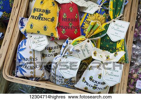 Stock Photograph - Herbs in fabric packets for sale in a basket; Provence, France. Fotosearch