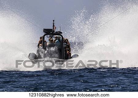 Stock Photograph - High speed rigid inflatable boat (RIB) making a big splash while entering Honakohau Harbor through ocean swell; Kona, Island of Hawaii, Hawaii, United States of America. Fotosearch