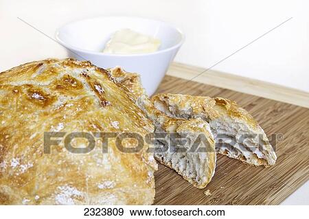 Stock Photo - Homemade bread on bamboo cutting board. Fotosearch