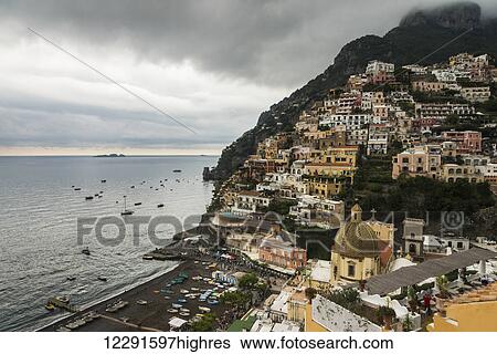 Stock Photograph - Houses on a hillside and boats in the water along the Amalfi coast; Positano, Campania, Italy. Fotosearch