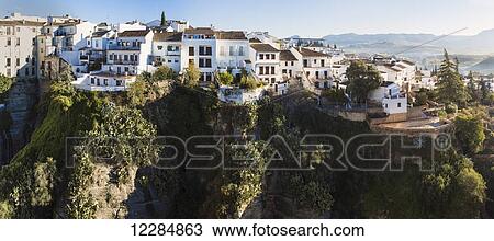 Stock Image - Houses sitting on the edge of the Tajo gorge; Ronda, Malaga Province, Andalusia, Spain. Fotosearch