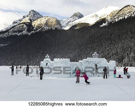 Stock Photograph - Ice skating on frozen Lake Louise with an ice sculpture; Lake Louise, Alberta, Canada. Fotosearch