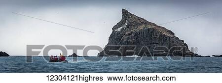 Inflatable cruises towards jagged rock at sea; Antarctica View Large Photo Image Stock Photograph - Inflatable cruises towards jagged rock at sea; Antarctica. Fotosearch