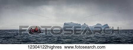Inflatable motors towards blue iceberg on horizon; Antarctica View Large Photo Image Stock Photograph - Inflatable motors towards blue iceberg on horizon; Antarctica. Fotosearch