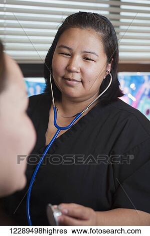 Inupiaq woman nurse checking a patient's heartbeat with a stethascope in the native hospital, Barrow, North Slope, Arctic Alaska View Large Photo Image Stock Photograph - Inupiaq woman nurse checking a patient's heartbeat with a stethascope in the native hospital, Barrow, North Slope, Arctic Alaska. Fotosearch