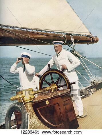 Stock Photography - King George V at the wheel of his yacht, Britannia, during Cowes Regatta Week, England, 1924. From The Illustrated London News, Silver Jubilee Record Number, 1910 - 1935. Fotosearch