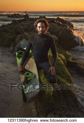 Stock Photograph - Kitesurfing professional, Maxi Gomez, on the beach at sunset; Tarifa, Cadiz, Costa de la Luz, Andalusia, Spain. Fotosearch