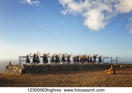 Stock Photograph - Kumu Keala Ching leads performance of Na Wai Iwi Ola on hula platform (hula pahu) at Kaana on Molokai, legendary birthplace of hula; Mauna Loa, Island of Hawaii, Hawaii, United States of America. Fotosearch