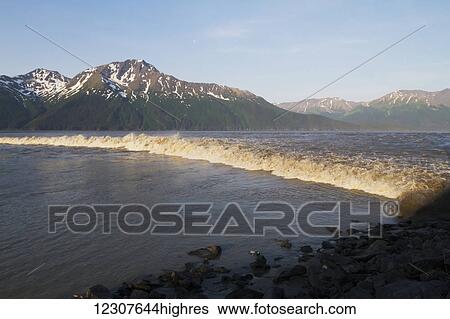 Stock Photograph - Large bore tide rolls across Turnagain Arm, Southcentral Alaska, USA. Fotosearch