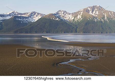 Stock Photograph - Large bore tide rolls across Turnagain Arm, Southcentral Alaska, USA. Fotosearch