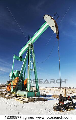Large pump jack in a snow covered field with snow covered foothills, blue sky and clouds in the background; Longview, Alberta, Canada View Large Photo Image Stock Photograph - Large pump jack in a snow covered field with snow covered foothills, blue sky and clouds in the background; Longview, Alberta, Canada. Fotosearch