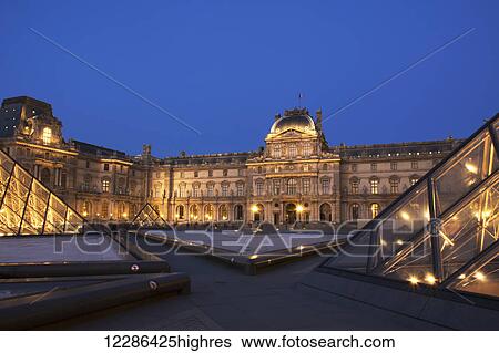 Le Louvre palace buildings and pyramids at night in golden light; Paris, France View Large Photo Image Stock Photograph - Le Louvre palace buildings and pyramids at night in golden light; Paris, France. Fotosearch