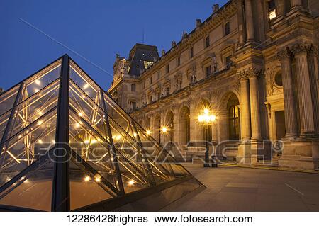 Le Louvre palace buildings and pyramids at night in golden light; Paris, France View Large Photo Image Stock Photograph - Le Louvre palace buildings and pyramids at night in golden light; Paris, France. Fotosearch