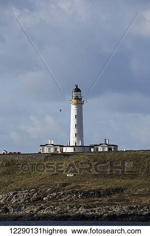 Stock Photograph - Lighthouse under a cloudy sky; Portnahaven, Isle of Islay, Scotland. Fotosearch