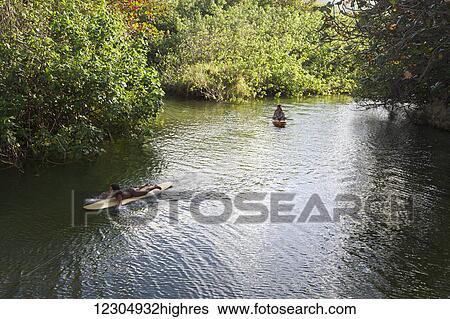 Stock Photograph - Local children float down Punaluu Stream; Punaluu, Oahu, Hawaii, United States of America. Fotosearch