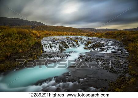 Long exposure of water flowing over rock in a stream and dark clouds in the sky; Bruarfoss, Iceland View Large Photo Image Stock Photograph - Long exposure of water flowing over rock in a stream and dark clouds in the sky; Bruarfoss, Iceland. Fotosearch