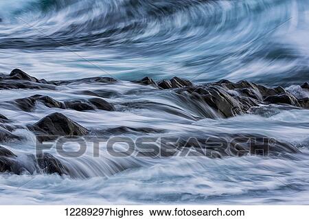 Long exposure of waves striking the coastline and flowing over rocks; Iceland View Large Photo Image Stock Photograph - Long exposure of waves striking the coastline and flowing over rocks; Iceland. Fotosearch