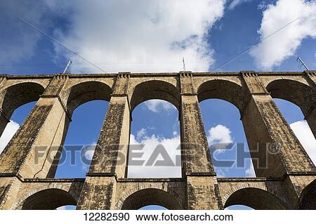Low angle of a stone arched viaduct with blue sky and clouds; Morlaix, Brittany, France View Large Photo Image Stock Image - Low angle of a stone arched viaduct with blue sky and clouds; Morlaix, Brittany, France. Fotosearch