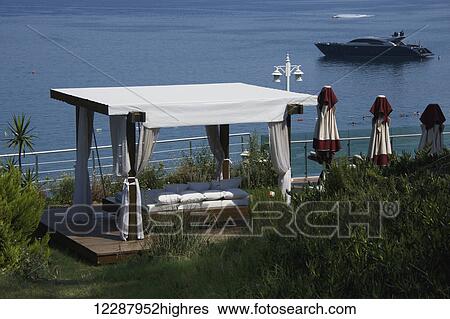 Stock Photograph - Luxury rocking sofa with view of cruiser; Turkey. Fotosearch