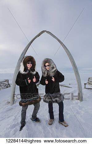 Male and female native youths wear traditional fur parkas while standing next to the Browerville Walebone arch, Barrow, North Slope, Arctic Alaska, USA, Winter View Large Photo Image Stock Photograph - Male and female native youths wear traditional fur parkas while standing next to the Browerville Walebone arch, Barrow, North Slope, Arctic Alaska, USA, Winter. Fotosearch