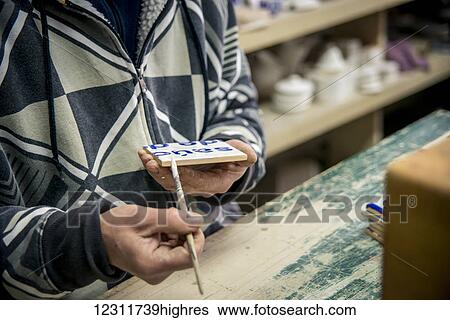 Man finishing touches on tiles at Vieira Pottery; Lagoa, Sao Miguel, Azores, Portugal View Large Photo Image Stock Photograph - Man finishing touches on tiles at Vieira Pottery; Lagoa, Sao Miguel, Azores, Portugal. Fotosearch