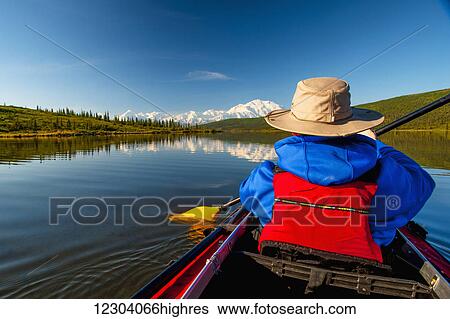 Stock Photograph - Man kayaking on Wonder Lake with Denali in the background, Interior Alaska, summer. Fotosearch