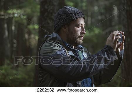 Man photographing the forest around Girdwood with his smartphone, Southcentral Alaska. View Large Photo Image Stock Image - Man photographing the forest around Girdwood with his smartphone, Southcentral Alaska.. Fotosearch