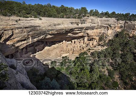 Stock Photograph - Mesa Verde National Parks Cliff Palace ancient dwellings in the evening sunlight with a clear blue sky; Colorado, United States of America. Fotosearch