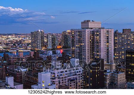 Stock Photograph - Midtown Manhattan with Gantry Plaza across East River at twilight; New York City, New York, United States of America. Fotosearch