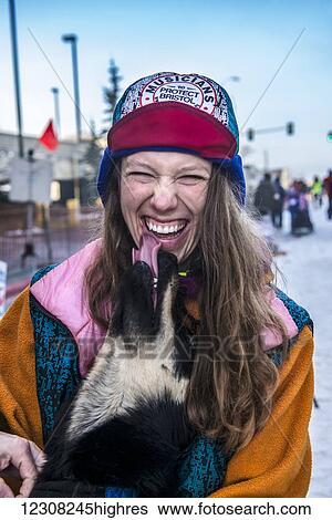 Stock Photograph - Monica Zappa gets kisses from one of her sled dogs before the ceremonial start of the Iditarod, Anchorage, Southcentral Alaska, USA. Fotosearch