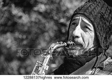 Stock Photograph - Mono close up of bearded saxophonist in hat; Athens, Attica, Greece. Fotosearch