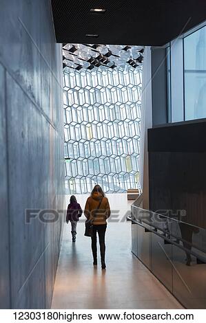 Stock Photograph - Mother and daughter explore interior of the Harpa public concert hall, designed by the Danish firm Henning Larsen Architects and the Icelandic firm Batteriao Architects, the glass facade designed by Icelandic glass artist Olafur Eliasson; Reykjavik,.... Fotosearch