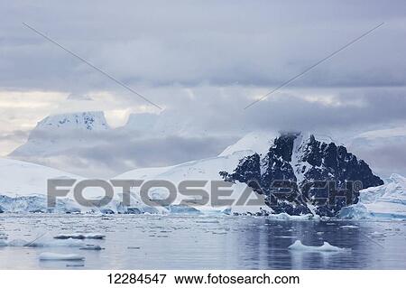 Mounatins vailed behind clouds in Paradise Harbour, Antarctic Peninsula; Antarctica View Large Photo Image Stock Photo - Mounatins vailed behind clouds in Paradise Harbour, Antarctic Peninsula; Antarctica. Fotosearch